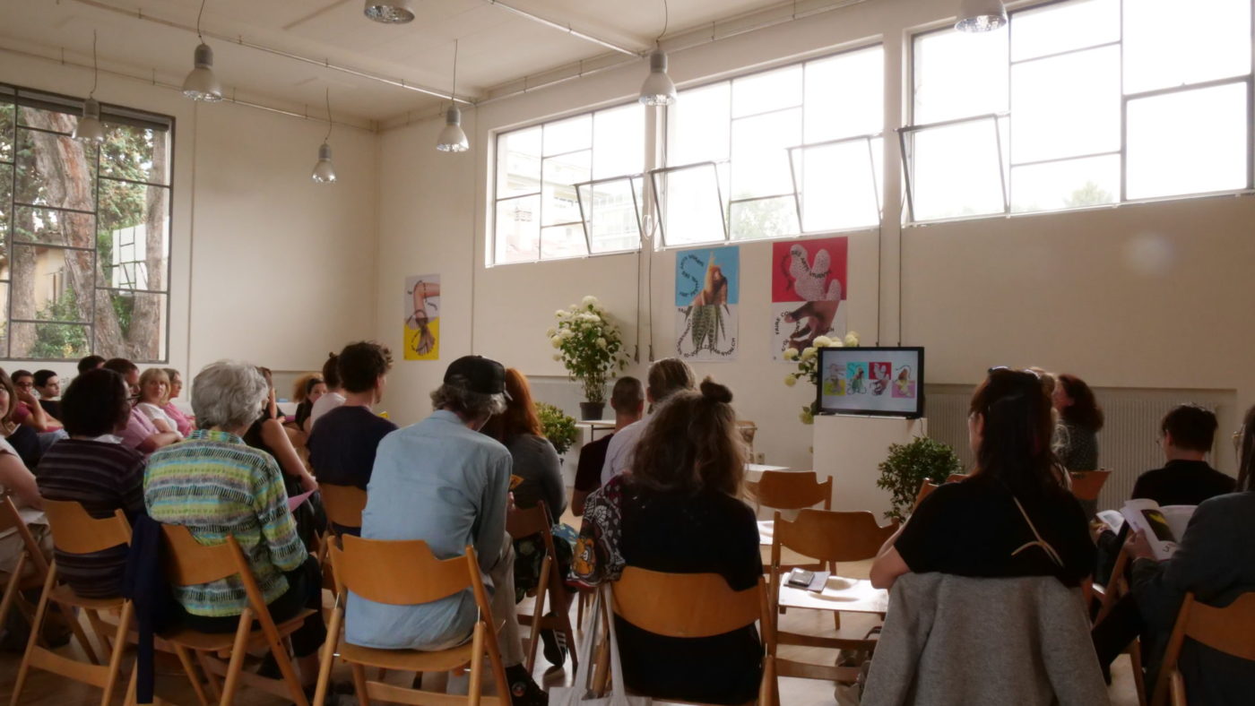The space of Les Marchandises is full of people on chairs. This place also serves to welcome the public for different events, on this photo the revelation of the programme.