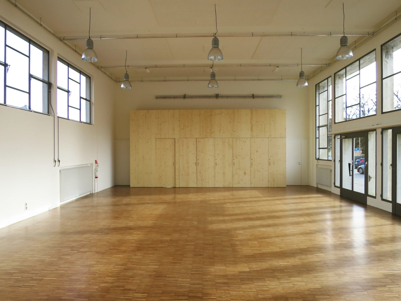 This is the interior of the salle des Marchandises. The space is bright with the numerous windows and there is a big wooden cupboard next to the far° office.