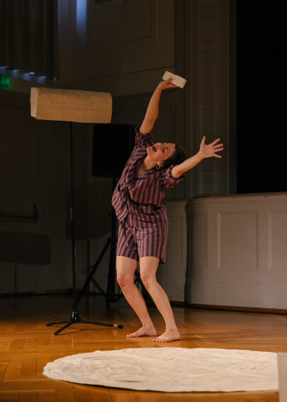 The artist Annina Polivka stands on the seen the arms in the air, imagining air refreshing her.