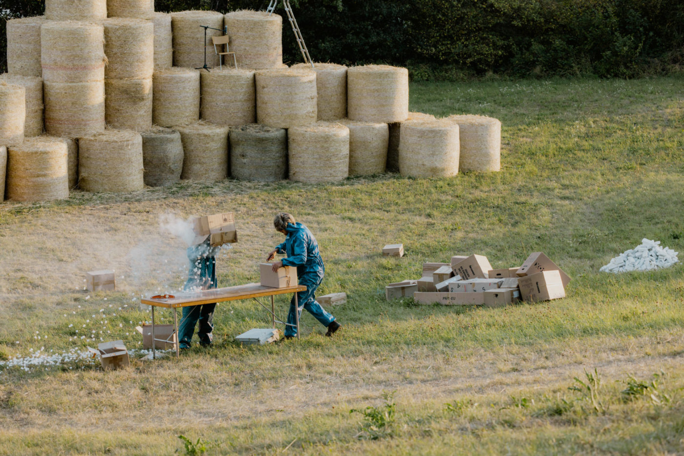 Two comedians stand on a field. In the back, we can discover a series of haystacks. One of the comedians opens a parcel and the other spills its content on his head. The content of the parcel is composed of dust and polystyrene.