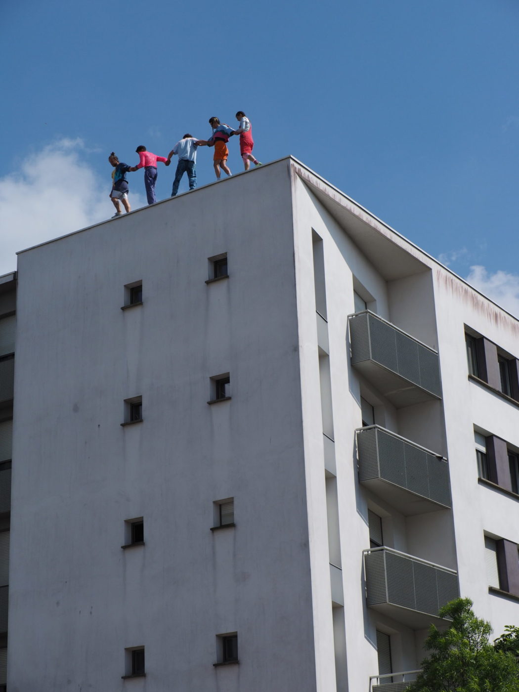 The five acrobats from la horde dans les pavés are on the roof of a building.